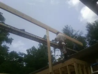 Carpenter setting a ridge beam over a new addition frame — Ice Dam Removal by Roofing Brothers in Marshallville