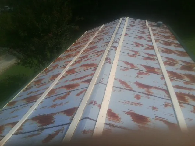 Rusted metal roof panels with new wood purlins before replacement — Storm Damage Roof Repair in Marshallville by Roofing Brothers