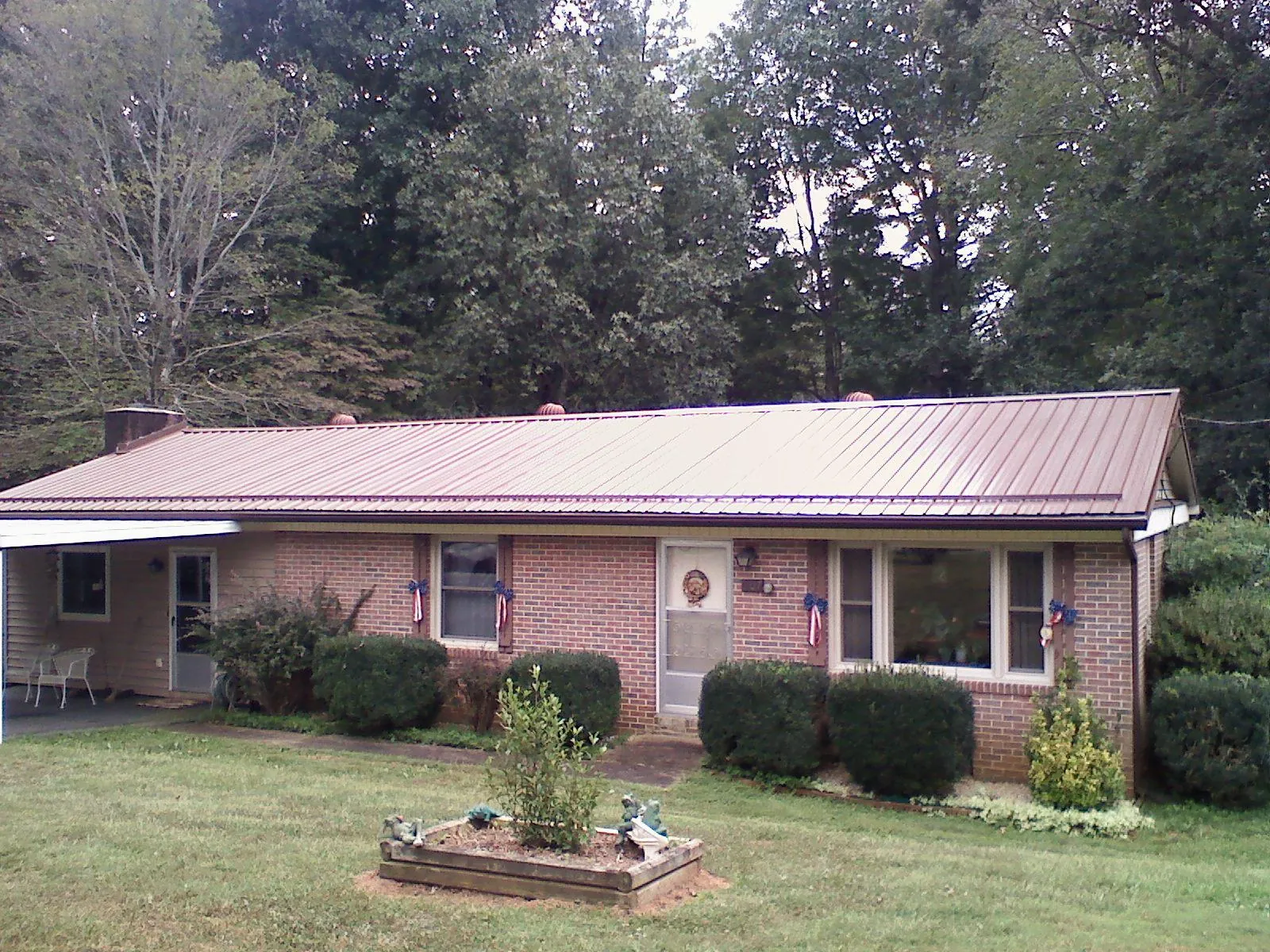 Bronze metal roof on a brick ranch home with a carport in Marshallville