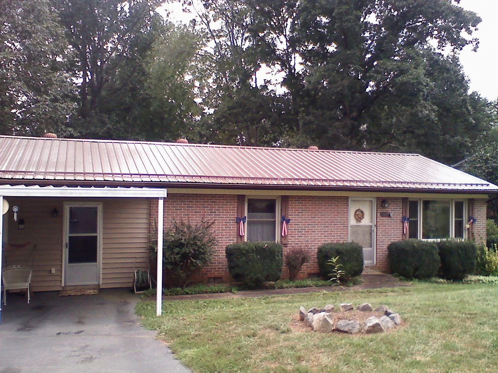 Bronze metal roof and carport on a brick ranch home — Roof Repair work by our crew in Marshallville