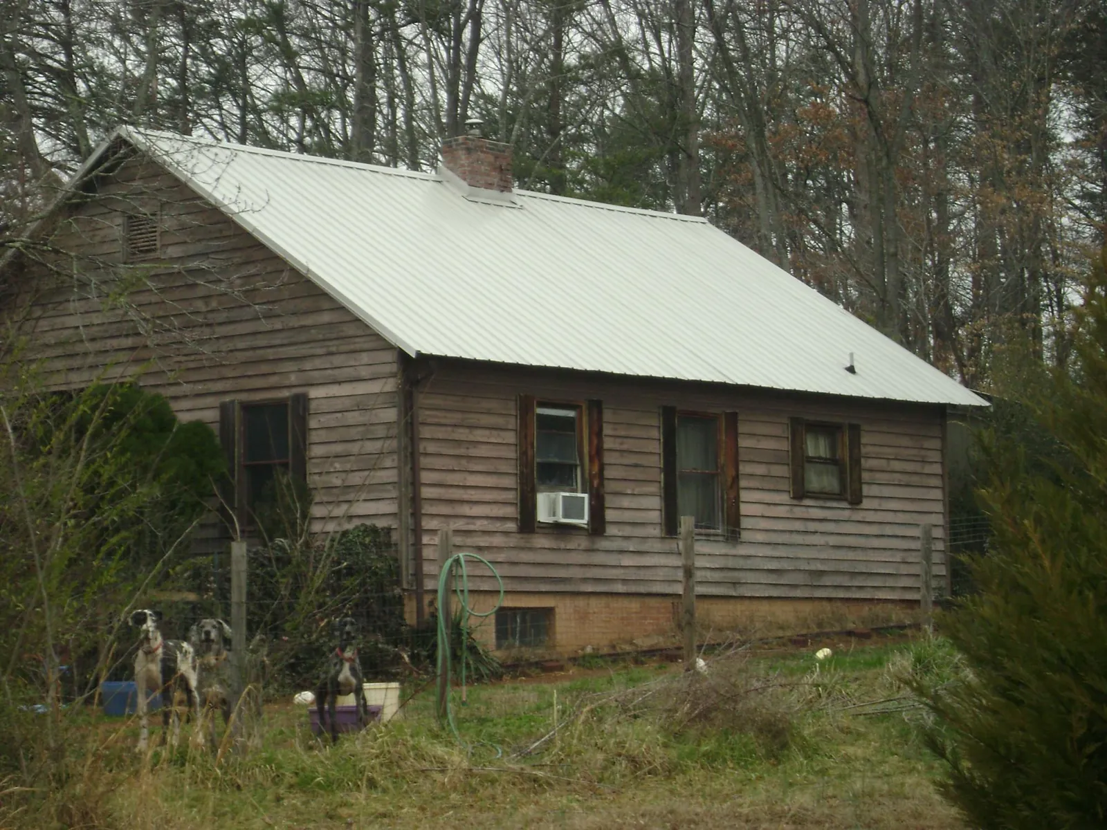White metal roof on an old wood sided farmhouse, from a Metal Roof Installation job in Marshallville